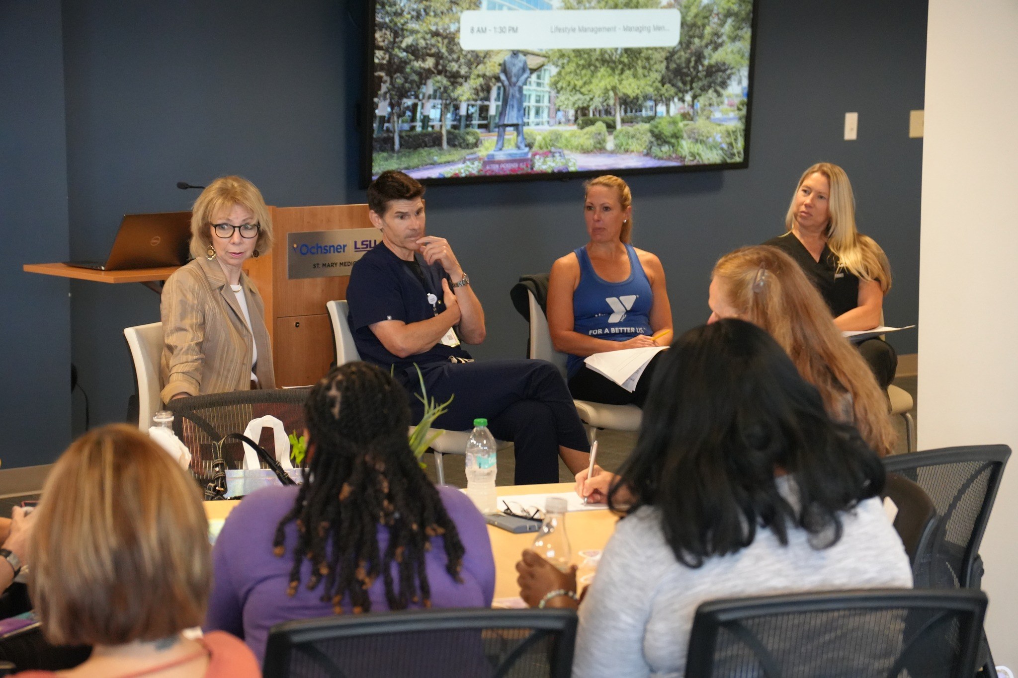 A group of community members look towards guest speakers.
